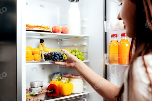 Preview: Woman hand taking, picks up box of blueberry out of open refrigerator, fridge