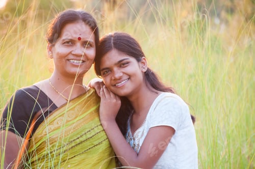 Preview: Portrait of happy mother and daughter in meadow at sunset. Smart Blurred photo