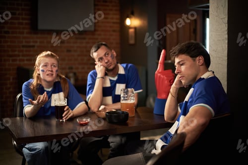 Preview: Group of Young Caucasian Soccer Fans Reacting Disappointedly in Pub at Team Loss