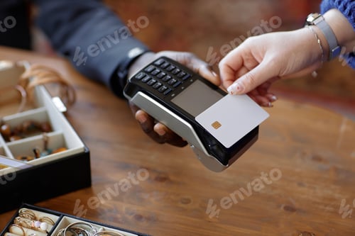 Preview: Hand of Customer Paying with Bank Card and Cashier with POS Terminal