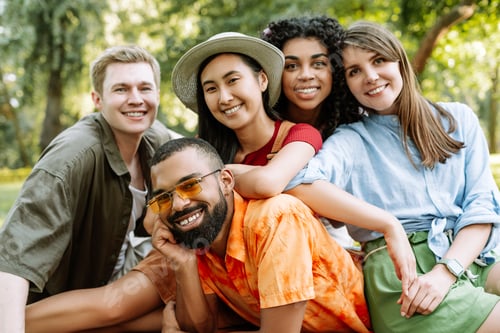 Preview: Group of diverse young multiracial women and men smiling and having fun together outdoors