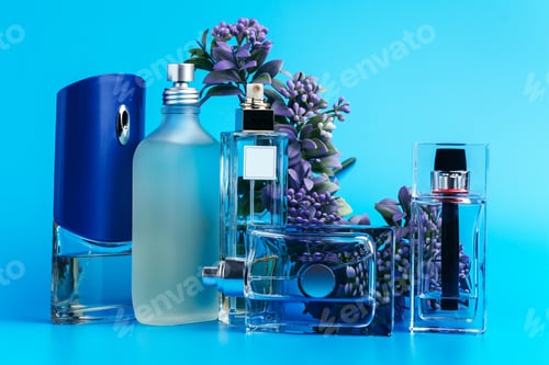 Vista previa: Perfume bottles with flowers on a light blue background