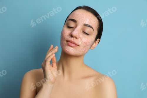 Preview: Woman with pomegranate face mask on light blue background