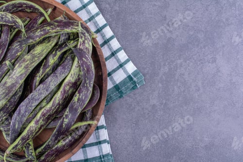 Preview: Green beans isolated in a wooden tray on blue background