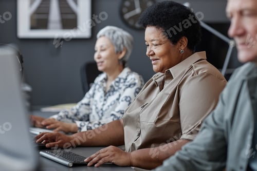 Preview: Senior black woman using computer and smiling in school for elderly people