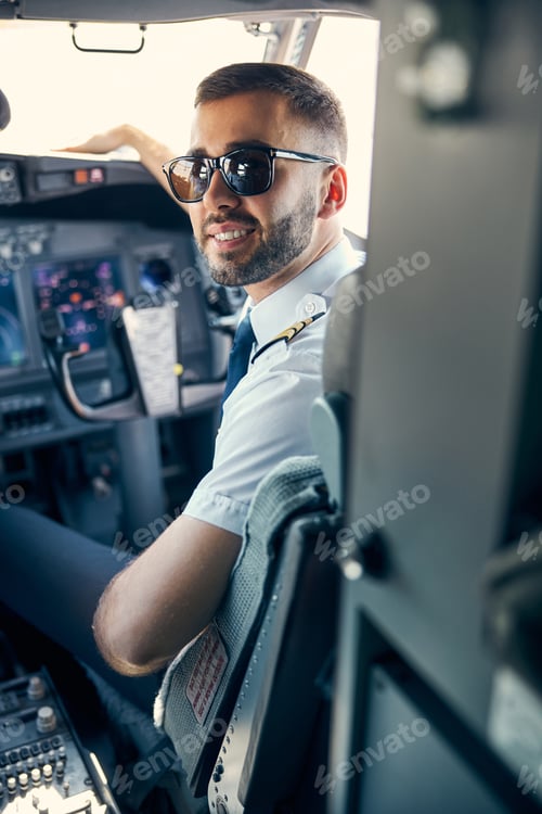 Preview: Bearded man wearing uniform and sunglasses sitting in the cabin of plane