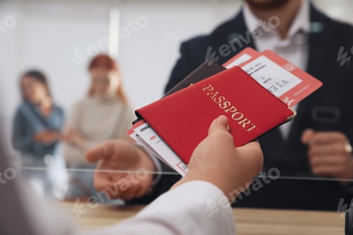 Preview: Agent giving passports with tickets to client at check-in desk in airport, closeup