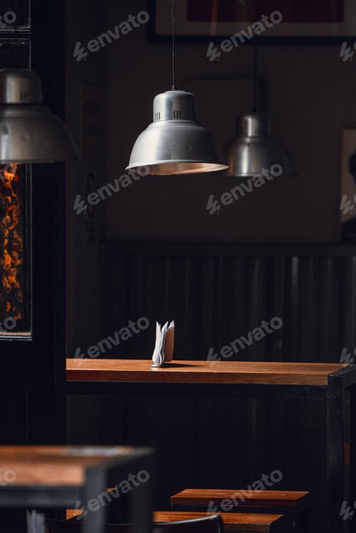 Preview: Beautiful view of the interior of the cafe with wooden tables and lamps hanging above
