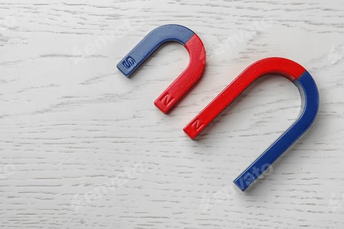 Preview: Red and blue horseshoe magnets on wooden background, top view with space for text