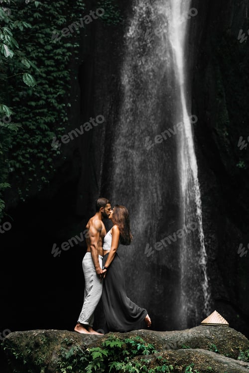 Preview: Beautiful couple at a waterfall in Indonesia. A couple in love travels around the island of Bali