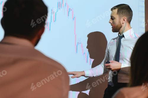 Preview: Young Businessman Explaining Graphs To His Colleagues On Projector