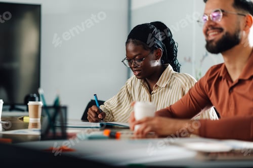 Preview: Young african american businesswoman taking notes during a meeting with her colleague