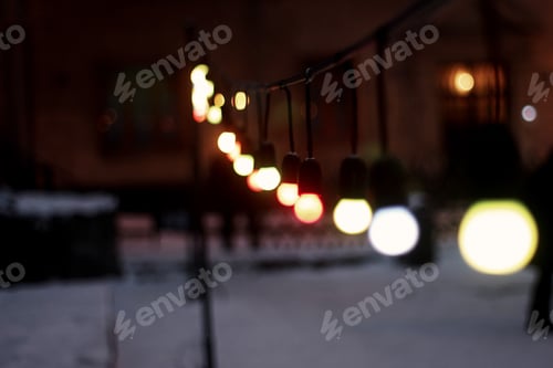 Preview: colorful retro garland lights bulbs at street in european city