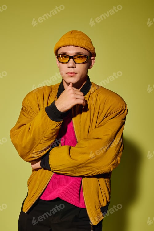Preview: Trendy young man showcases modern fashion with confidence in studio setting