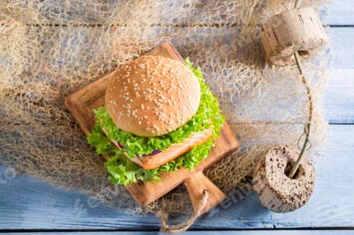 Preview: Fresh burger with fish and vegetables on old wooden table