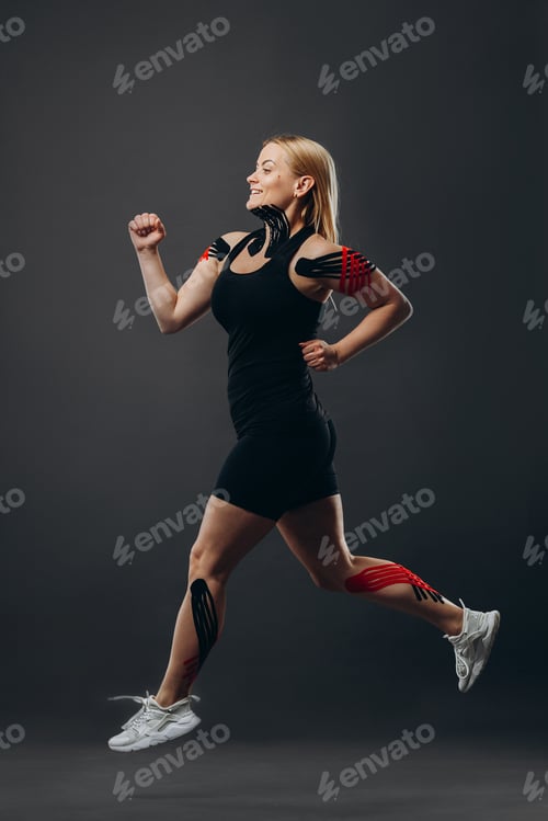 Preview: Young woman running with kinesio taping on body