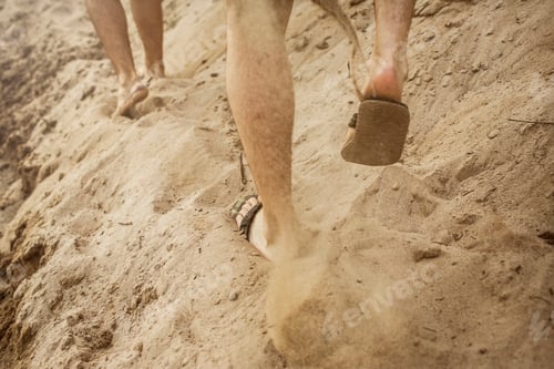 Preview: Two friends walking in sand, partial view