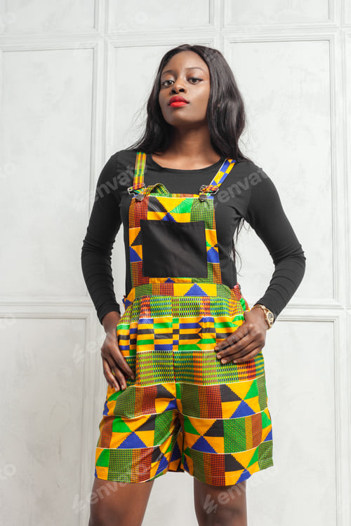 Preview: Model poses in colorful outfit with geometric patterns in studio setting