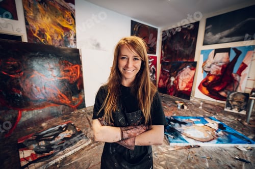 Preview: Young redhead woman painter standing by her art masterpiece on a big canvas