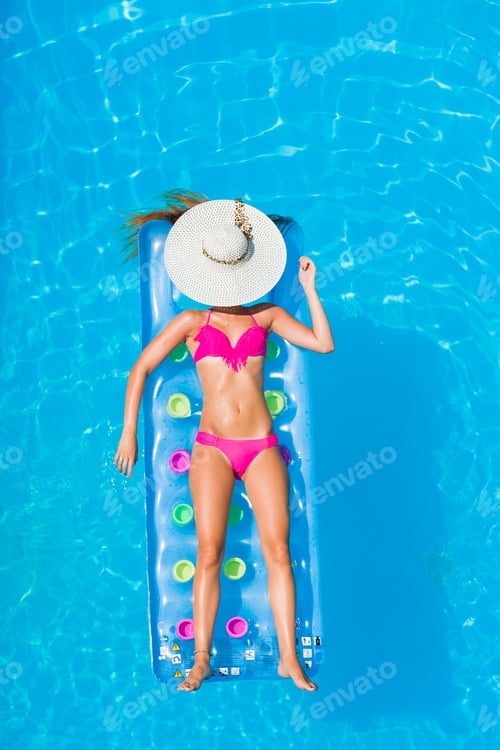 Preview: Young woman on a lilo in the swimming pool