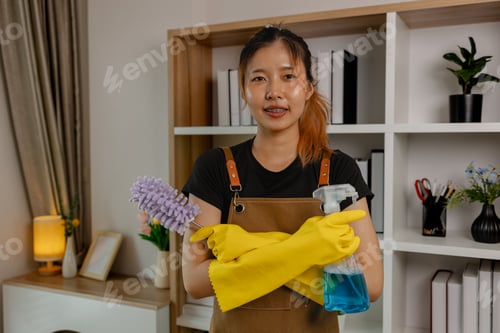 Preview: she is posting and looking at camera wears gloves, holding spray bottle and smile, get ready to clea