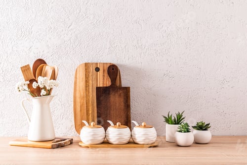 Preview: cutting wooden boards, a set of spice jars, wooden spoons in jug on a wooden countertop. Cozy house