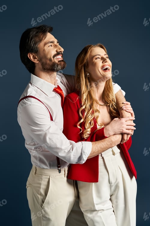 Preview: Joyful moments between a middle aged couple in stylish attire against a blue backdrop