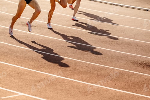 Preview: women legs and shadows on red track stadium, middle distance running race