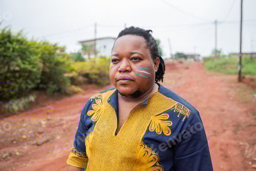 Vista previa: Retrato de un hombre trans africano seguro de sí mismo con la bandera dibujada en la mejilla al aire libre