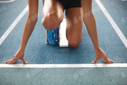 Preview: Young female athlete on starting blocks, close up