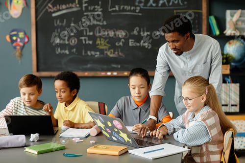 Preview: Male Teacher Helping Students with Using Laptop in Classroom