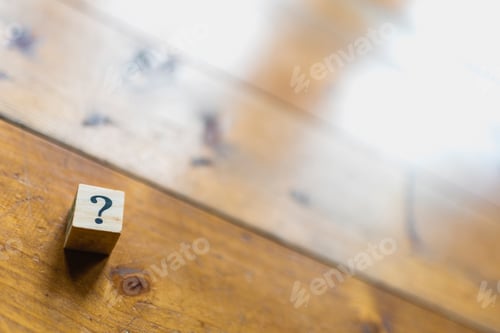 Preview: Wooden dice with question mark and doubt.
