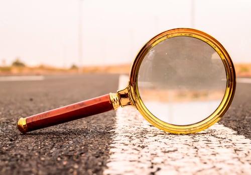 Preview: Closeup shot of a magnifying glass on a road street with a blurred background