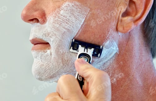 Preview: Closeup of a profile view of an adult male shaving