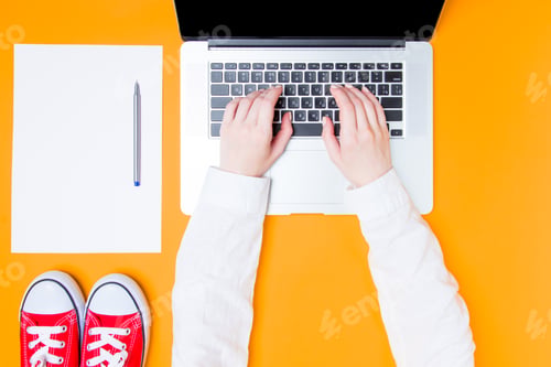 Preview: Businesswoman making notes with laptop and paper