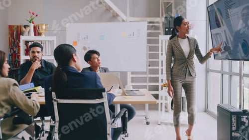 Preview: Confident businesswoman presenting during a business meeting with colleagues.