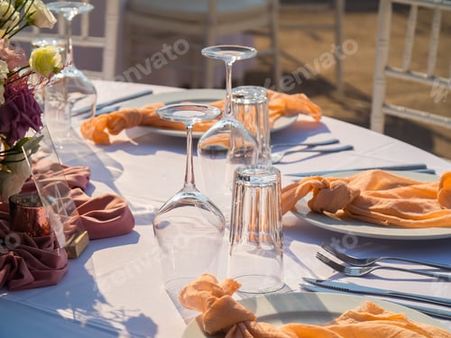 Preview: Table at luxury wedding reception event. Beautiful flowers on table and serving dishes and glasses