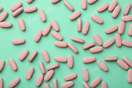 Preview: Pink vitamin capsules on turquoise background, top view