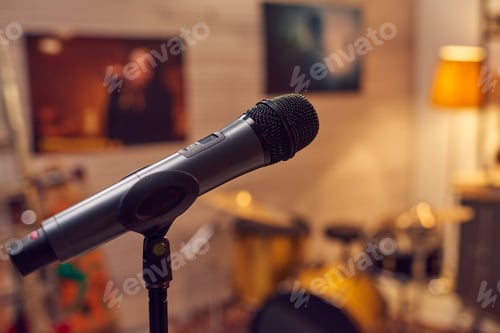 Preview: Black microphone against posters of female musicians