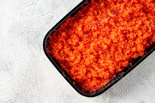 Preview: container with orange caviar, flying fish, Tobiko, on the table, caviar for rolls and sushi,