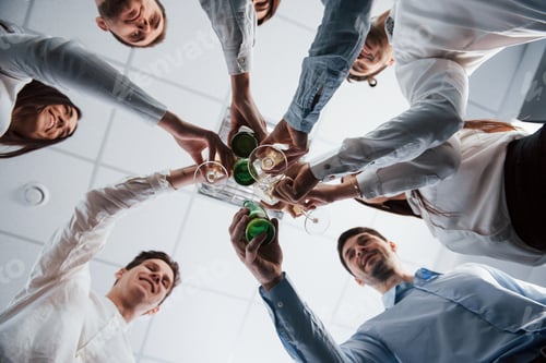 Preview: Photo from below. Knocking glasses in the office. Celebrating success