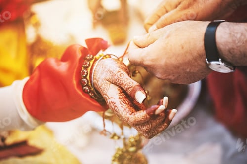 Preview: Men ties the holy thread on the wrist of indian bride during puja (pooja) belief to protect her from