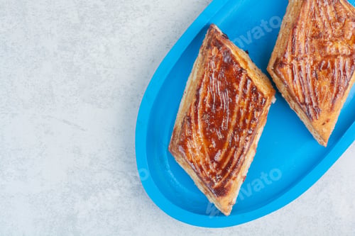 Preview: Two fresh delicious pastry on blue plate