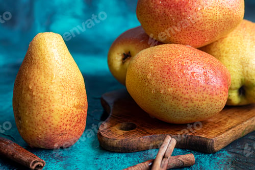 Preview: Pears on a dark background. Fresh, ripe fruits on a blue plate and in a box. Healthy eating.