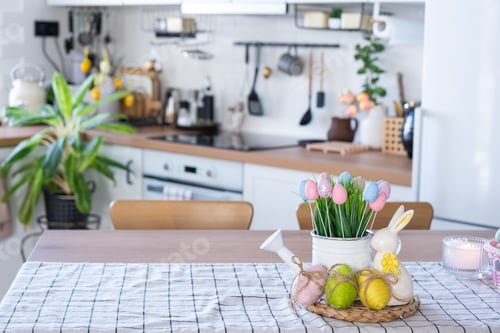 Preview: Easter decoration of colorful eggs in a basket and a rabbit on the kitchen table