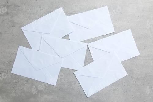 Preview: a stack of white envelope scattered on a grey background.