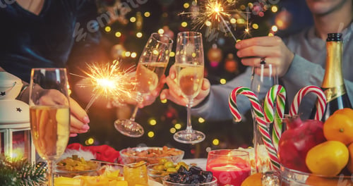 Preview: Champagne in hand against the background of the Christmas tree. People. Selective focus.