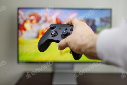 Preview: There's a gamepad in the background of the game monitor in his hands Video game gamepad in hand