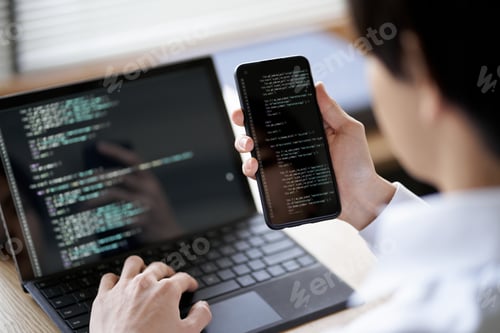 Preview: Asian programmer checking the operation of the code
