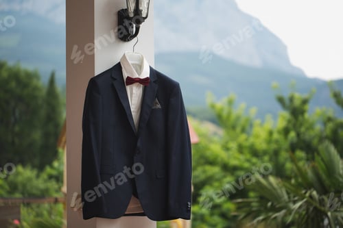 Preview: Groom suit jacket on a hanger mountain in the background